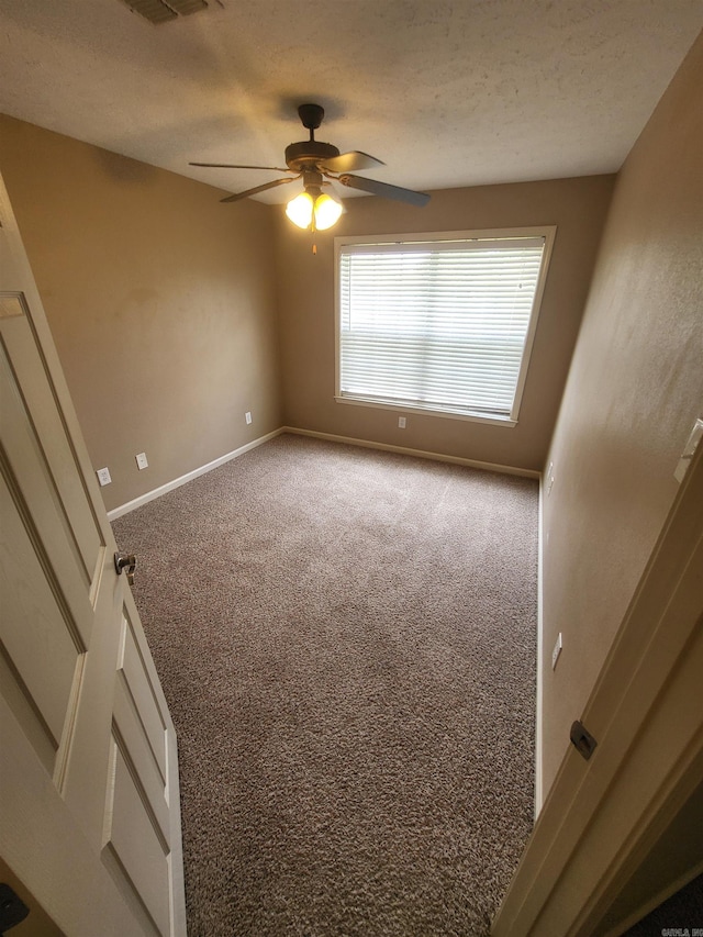 empty room with ceiling fan, a textured ceiling, and carpet floors