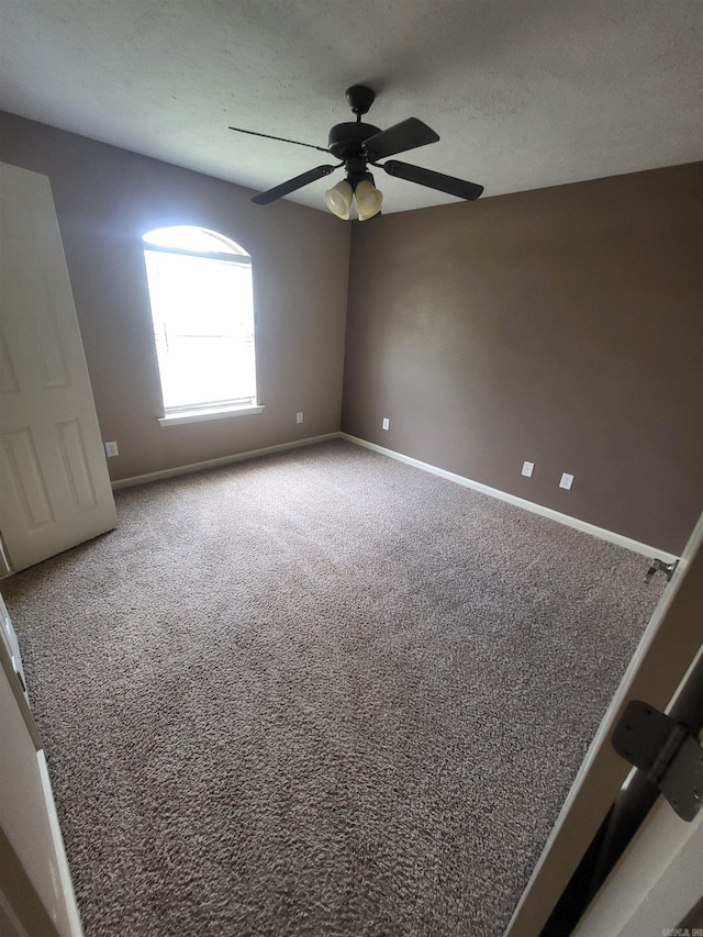 spare room with carpet flooring, ceiling fan, and a textured ceiling