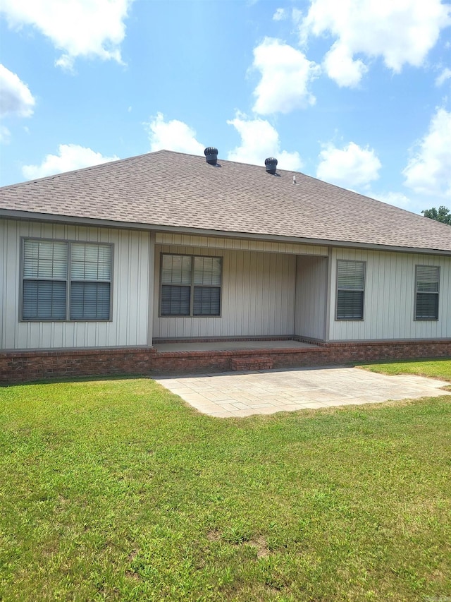 back of house with a lawn and a patio