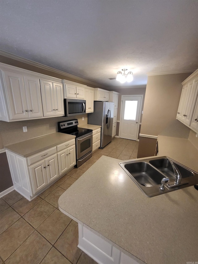 kitchen with ornamental molding, appliances with stainless steel finishes, white cabinetry, and light tile patterned floors