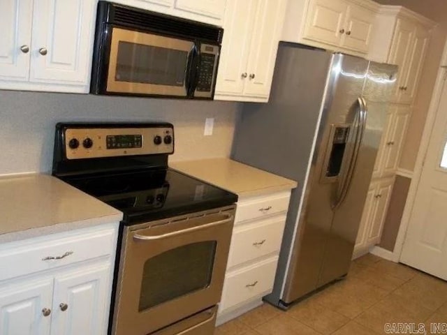 kitchen with stainless steel appliances, light tile patterned floors, and white cabinetry