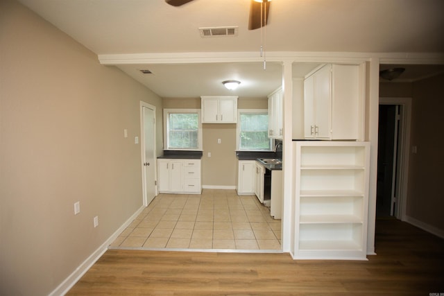 kitchen with light wood-type flooring, white cabinets, ceiling fan, and sink