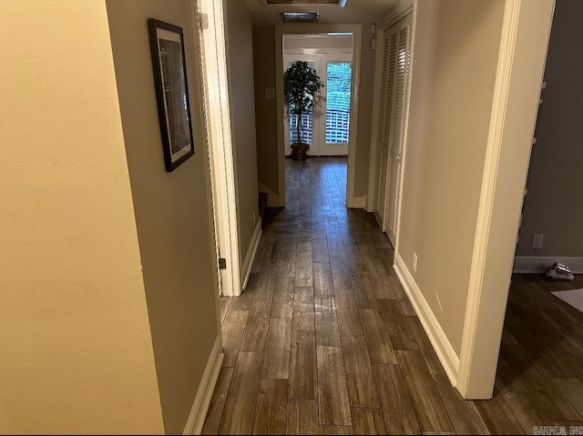 corridor with dark hardwood / wood-style flooring