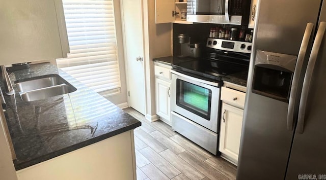 kitchen with white cabinets, backsplash, stainless steel appliances, light hardwood / wood-style floors, and sink