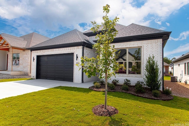 view of front of home with a garage, central AC, and a front yard