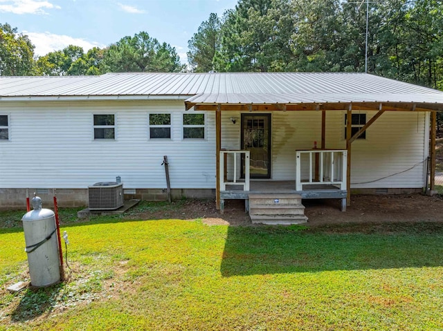 back of house featuring a lawn and cooling unit