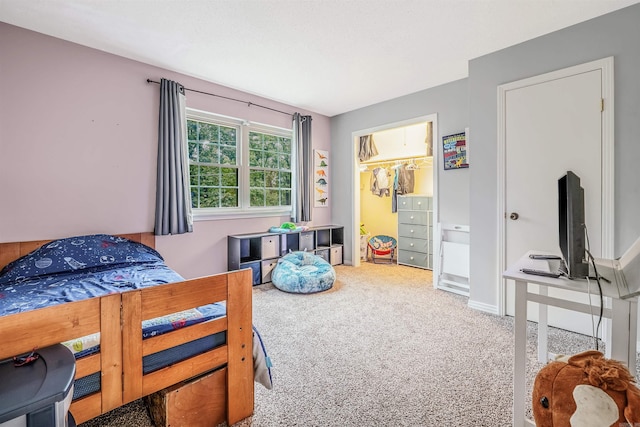 carpeted bedroom with a closet and a spacious closet