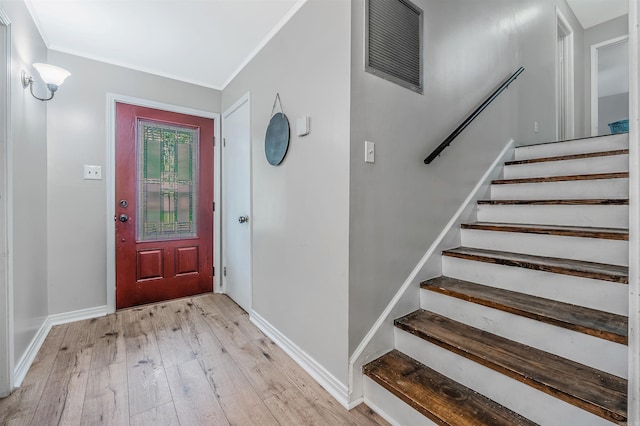 foyer with crown molding and light wood-type flooring