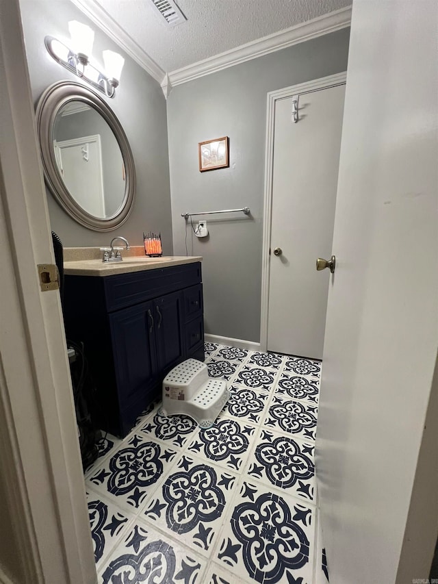 bathroom featuring a textured ceiling, vanity, ornamental molding, and tile patterned floors