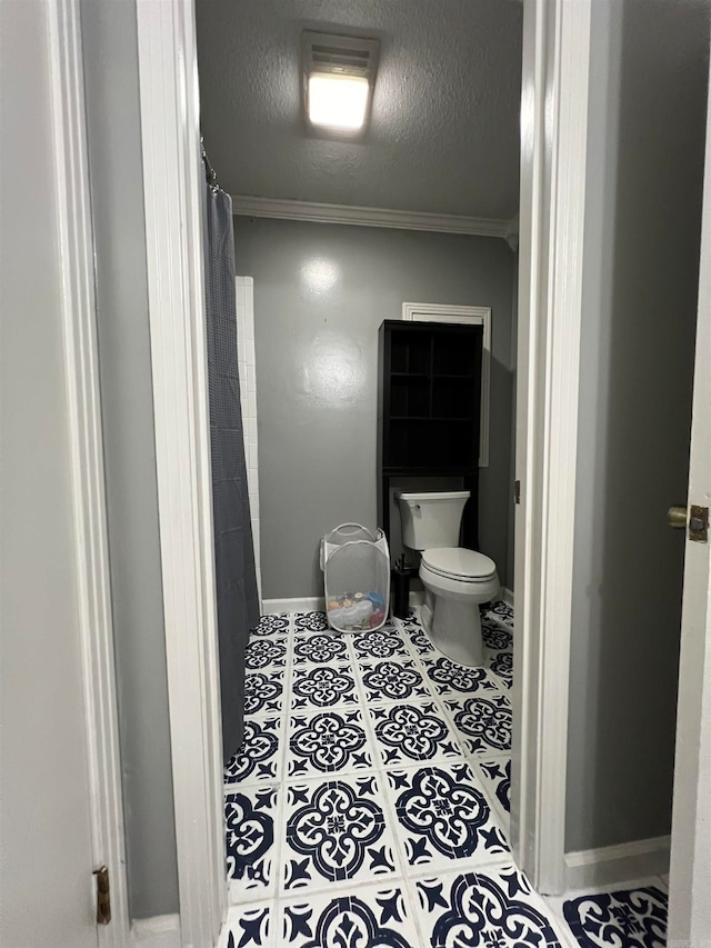 bathroom featuring crown molding, toilet, curtained shower, and tile patterned floors