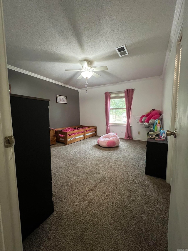 bedroom with ceiling fan, carpet floors, crown molding, and a textured ceiling