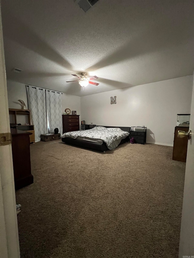 carpeted bedroom with ceiling fan and a textured ceiling