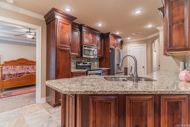 kitchen featuring appliances with stainless steel finishes, light stone countertops, sink, and ceiling fan