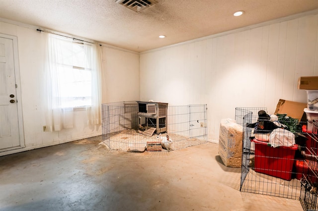 miscellaneous room featuring a textured ceiling and concrete floors