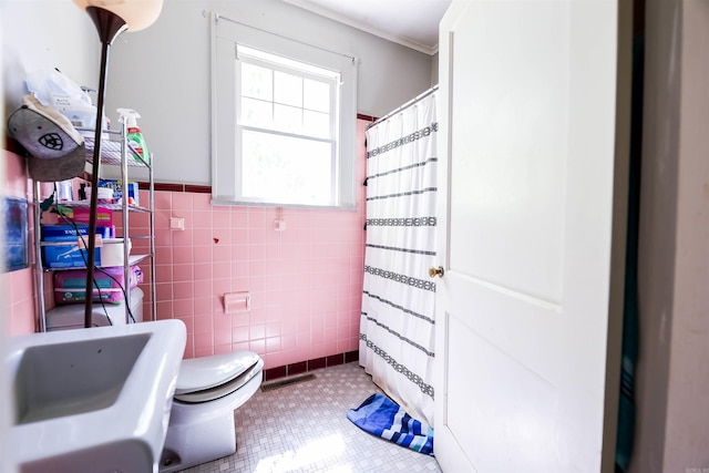 bathroom featuring toilet, crown molding, sink, tile walls, and a shower with curtain