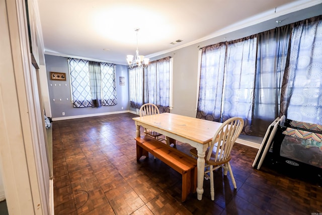 dining space featuring crown molding, dark parquet floors, and an inviting chandelier