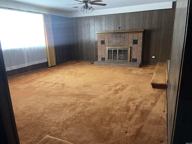 unfurnished living room with carpet floors, a textured ceiling, and wood walls