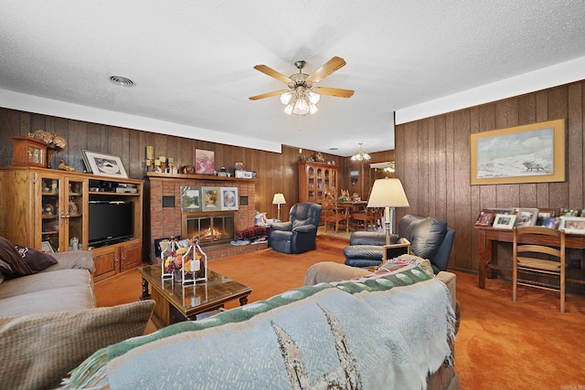 carpeted living room featuring visible vents, a textured ceiling, wooden walls, and ceiling fan
