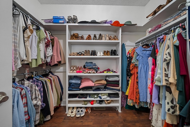 walk in closet with dark hardwood / wood-style flooring