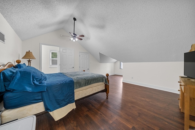 bedroom with a textured ceiling, dark wood-type flooring, ceiling fan, and vaulted ceiling