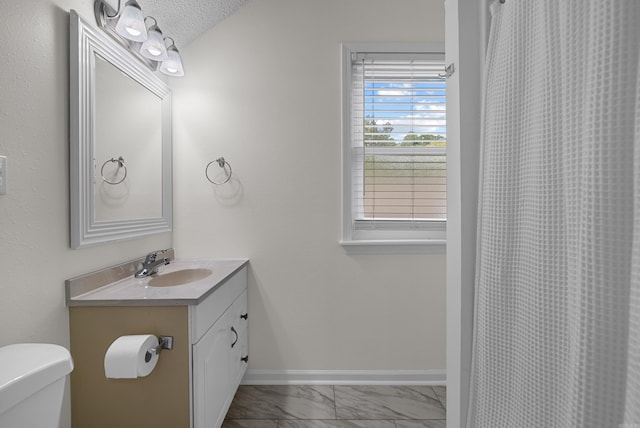 bathroom featuring vanity, toilet, walk in shower, and a textured ceiling