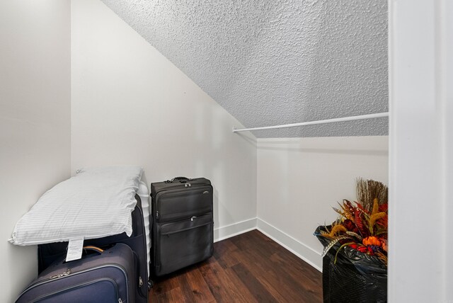 living area featuring vaulted ceiling, dark hardwood / wood-style flooring, and a textured ceiling