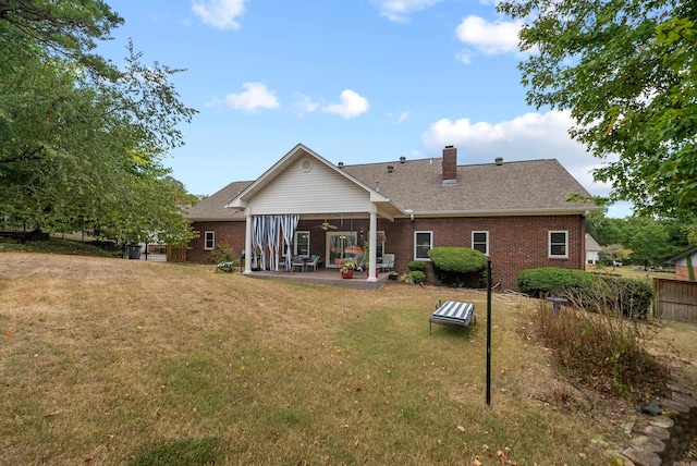 rear view of property with a yard and a patio