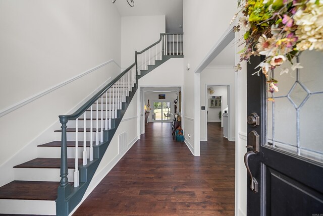 foyer featuring dark hardwood / wood-style floors and a towering ceiling