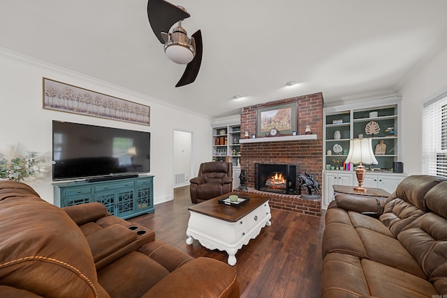 living room featuring crown molding, ceiling fan, a brick fireplace, and dark hardwood / wood-style flooring