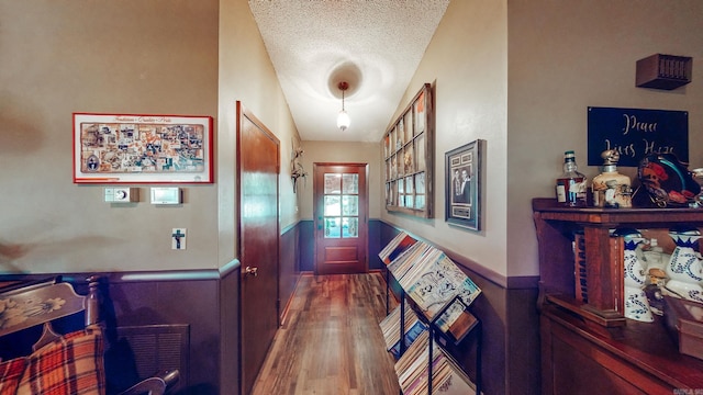 corridor featuring a textured ceiling and wood-type flooring