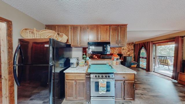 kitchen with hardwood / wood-style floors, black appliances, and a textured ceiling