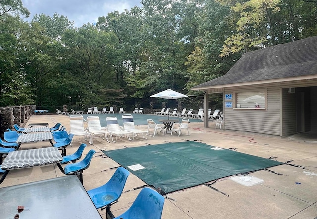 view of swimming pool featuring a patio area and an outbuilding