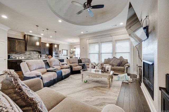 living room with wood-type flooring, ceiling fan, and crown molding