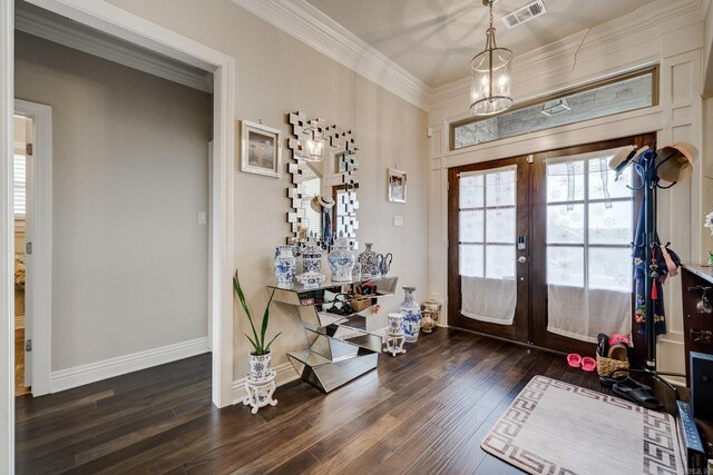 foyer entrance featuring a chandelier, crown molding, french doors, and dark hardwood / wood-style flooring