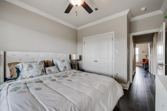 bedroom with a closet, ceiling fan, crown molding, and dark hardwood / wood-style flooring