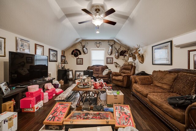 living room with lofted ceiling, an AC wall unit, dark wood-type flooring, and ceiling fan