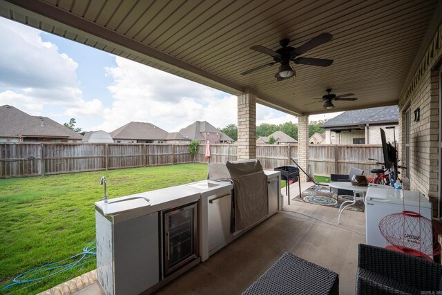 view of patio with ceiling fan, beverage cooler, and exterior kitchen