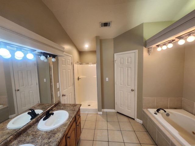 bathroom featuring vanity, independent shower and bath, tile patterned flooring, and vaulted ceiling