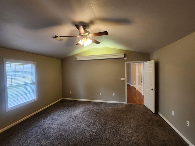 carpeted spare room featuring ceiling fan and vaulted ceiling