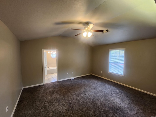 carpeted spare room with ceiling fan and vaulted ceiling