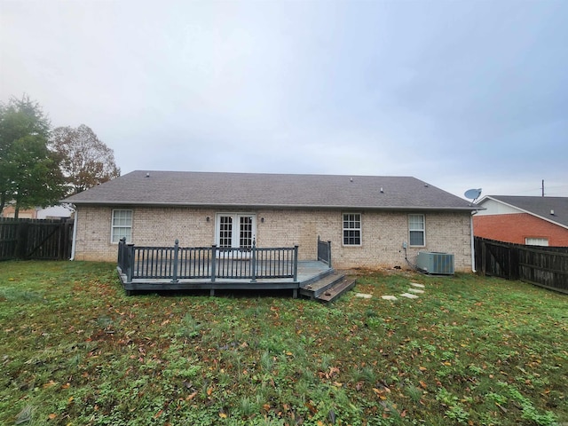 rear view of house with a deck, cooling unit, and a yard