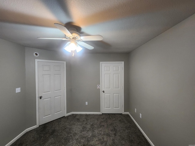 carpeted spare room featuring ceiling fan and a textured ceiling