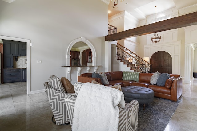 living room featuring a towering ceiling and crown molding