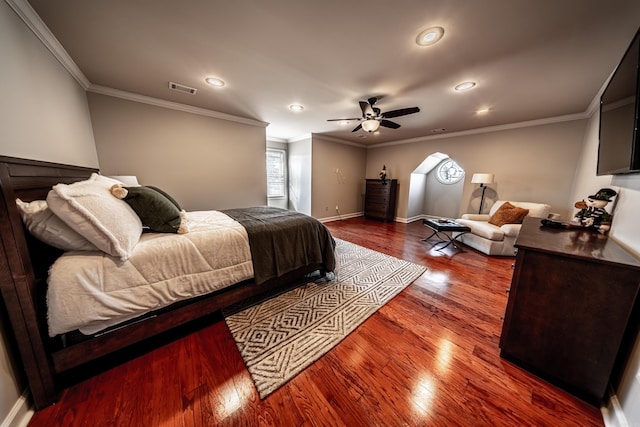 bedroom featuring crown molding, dark wood-type flooring, and ceiling fan