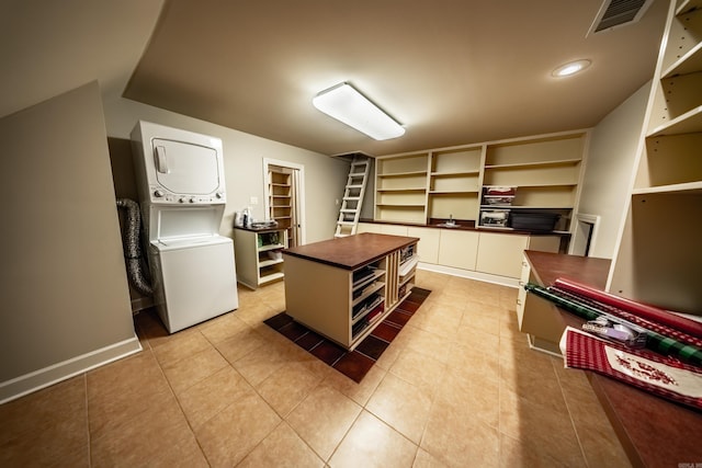 interior space with light tile patterned floors and stacked washer / drying machine