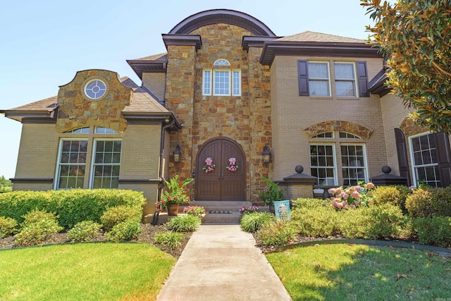 view of front of house with french doors and a front lawn