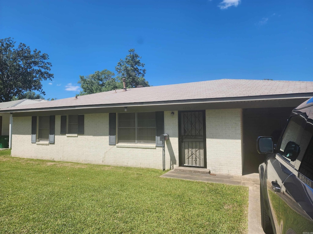 rear view of property featuring a yard