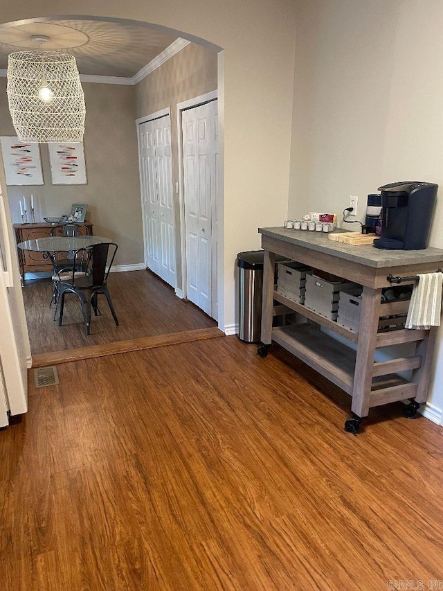 dining space featuring ornamental molding and wood-type flooring