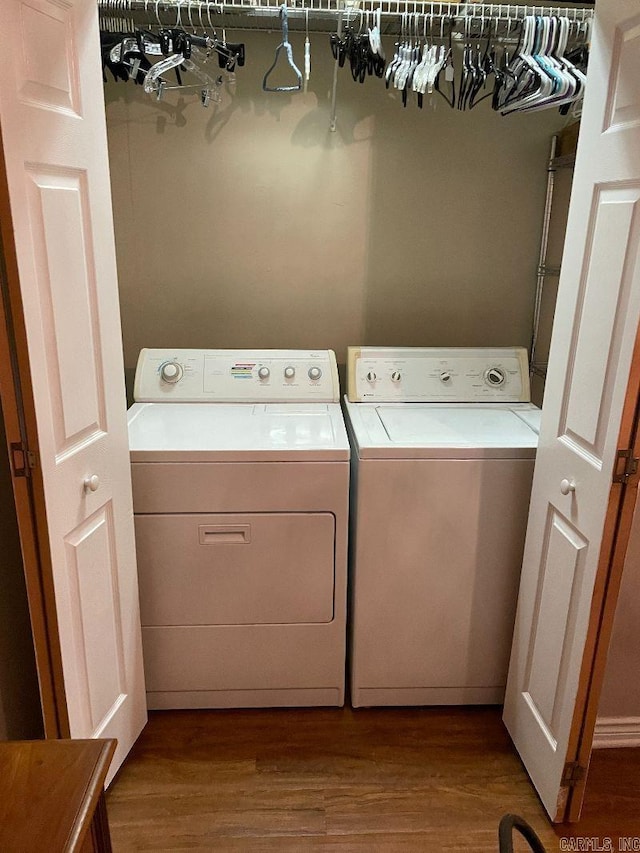 laundry area with separate washer and dryer and light wood-type flooring