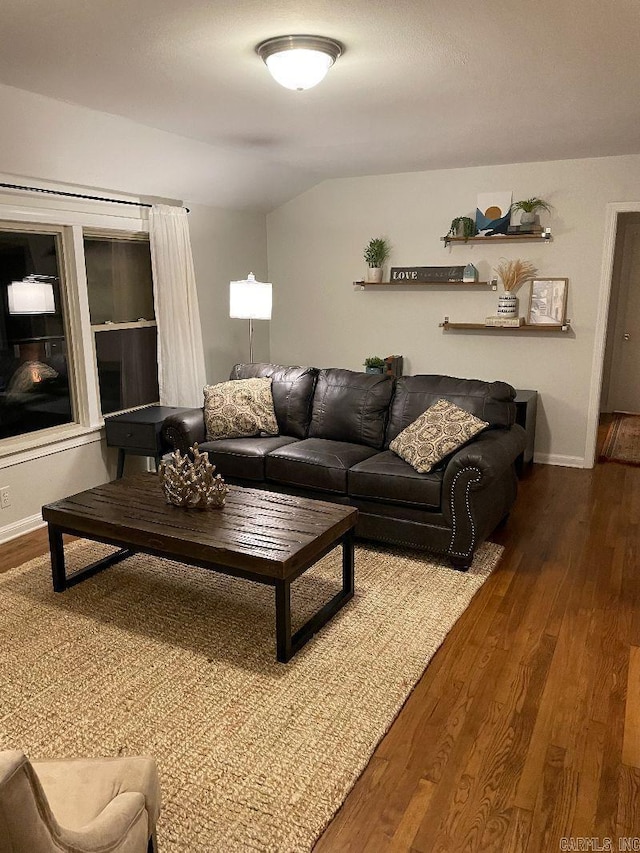living room featuring vaulted ceiling, wood finished floors, and baseboards